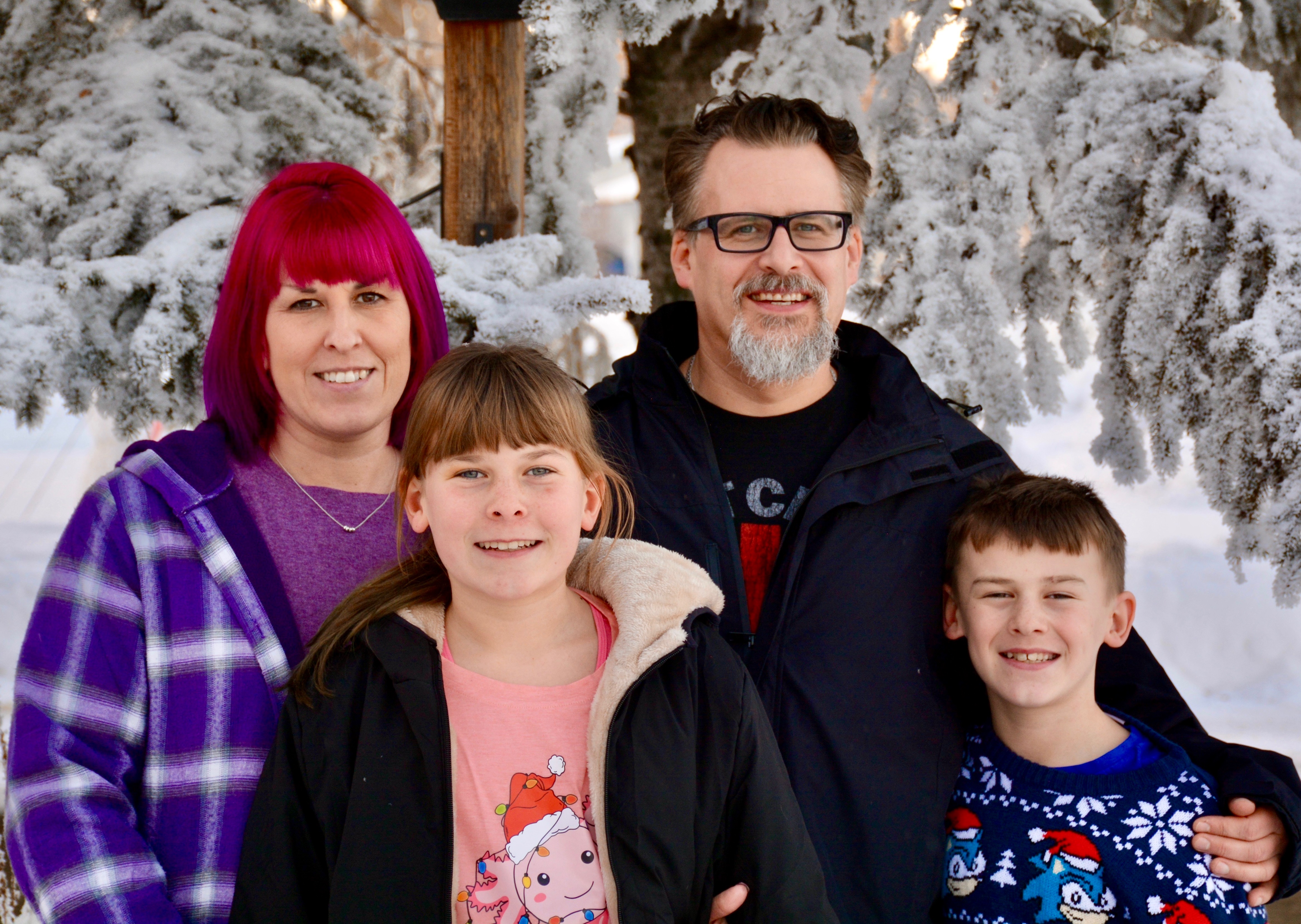Tom Mathews with his wife and two children outdoors in Minnedosa during winter